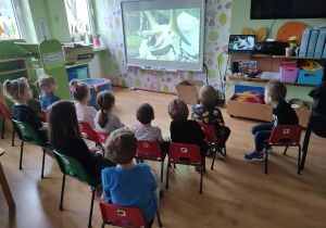 Dzieci oglądają film edukacyjny o dinozaurach